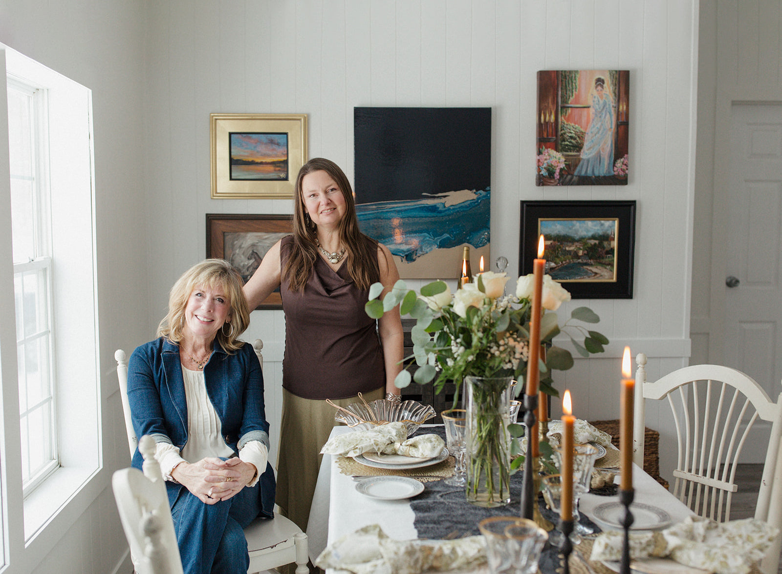 woman sitting at elegantly styled dining table with woman standing behind her